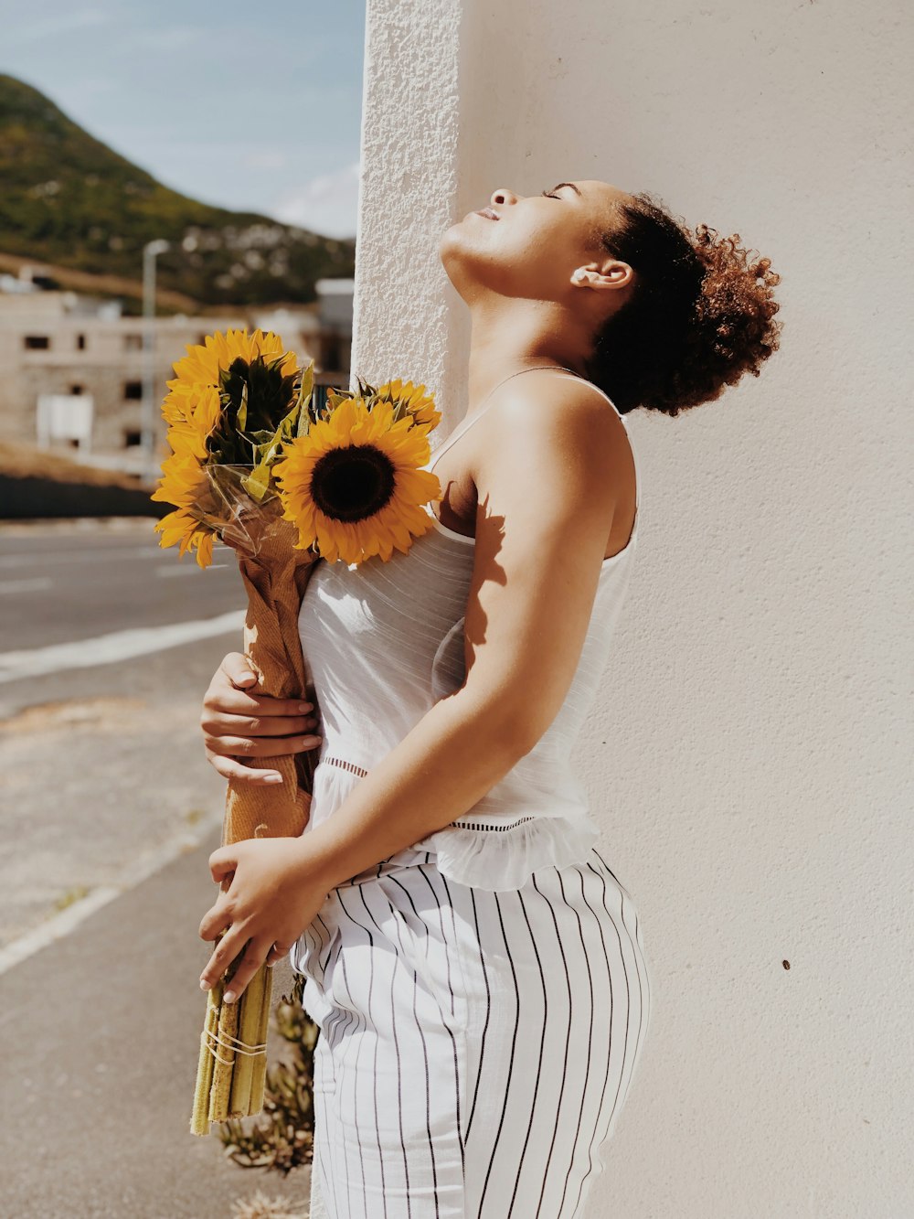 Mujer sosteniendo girasol en jarrón