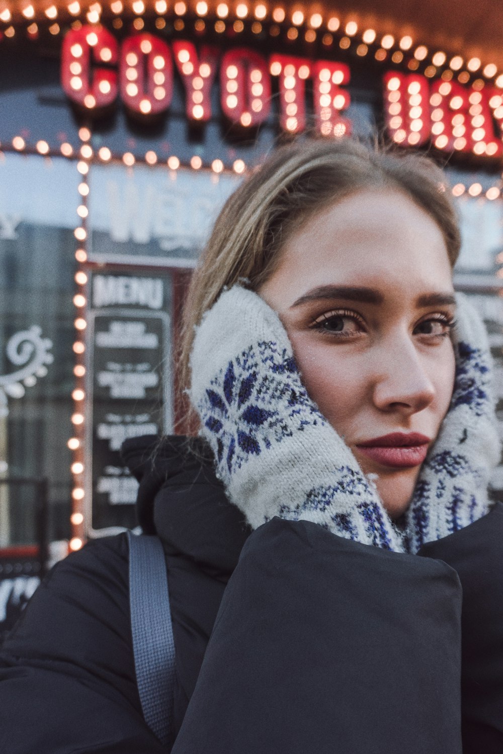 woman beside coyote ugly shop front