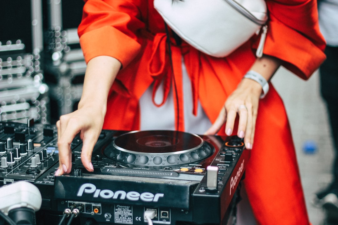 woman playing black Pioneer turntable