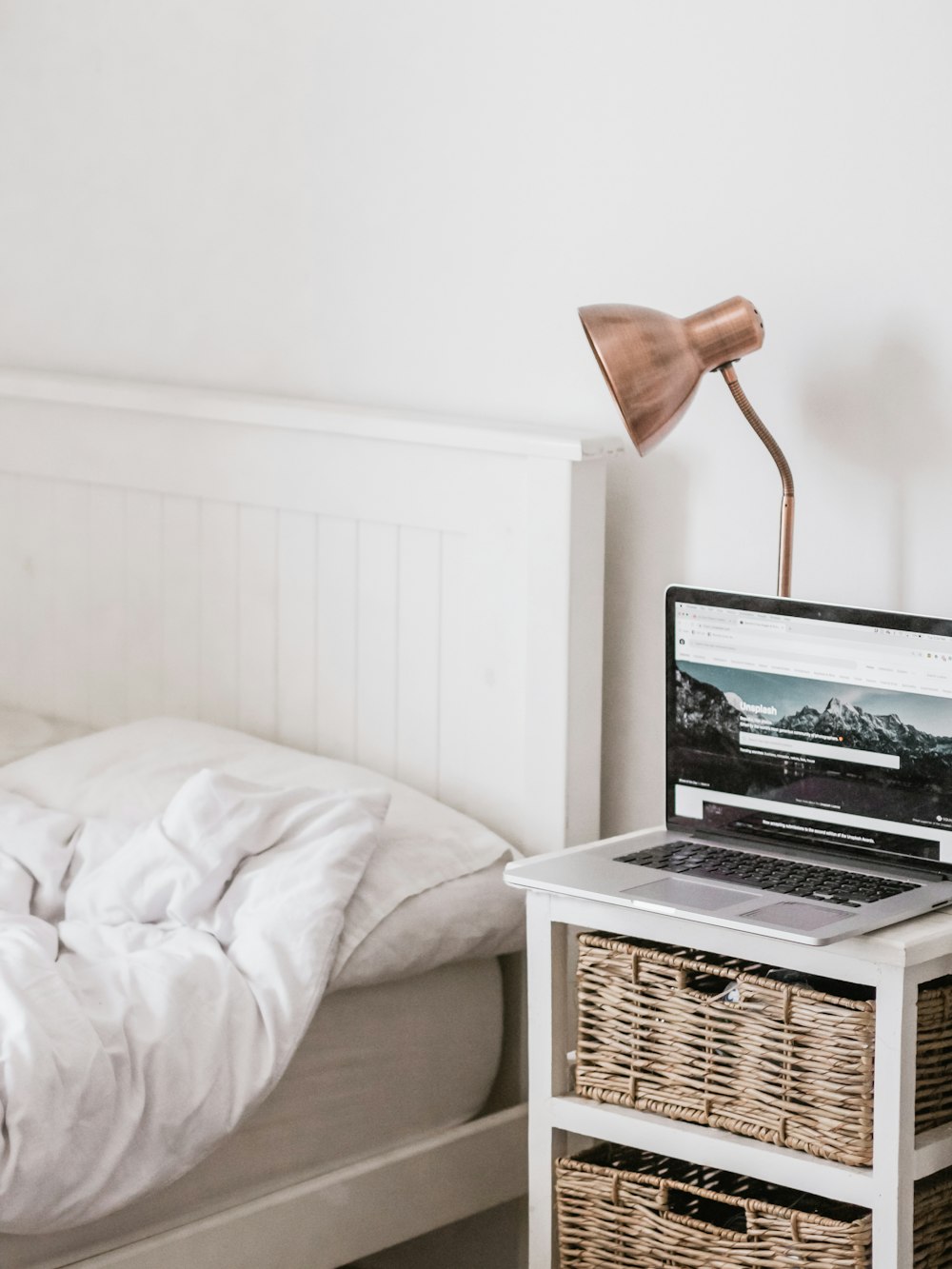 MacBook Pro sur le dessus d’une table d’appoint blanche