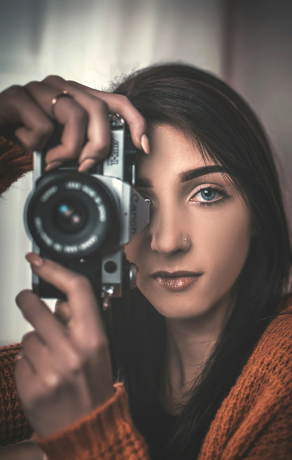 mujer usando una cámara Canon DSLR gris