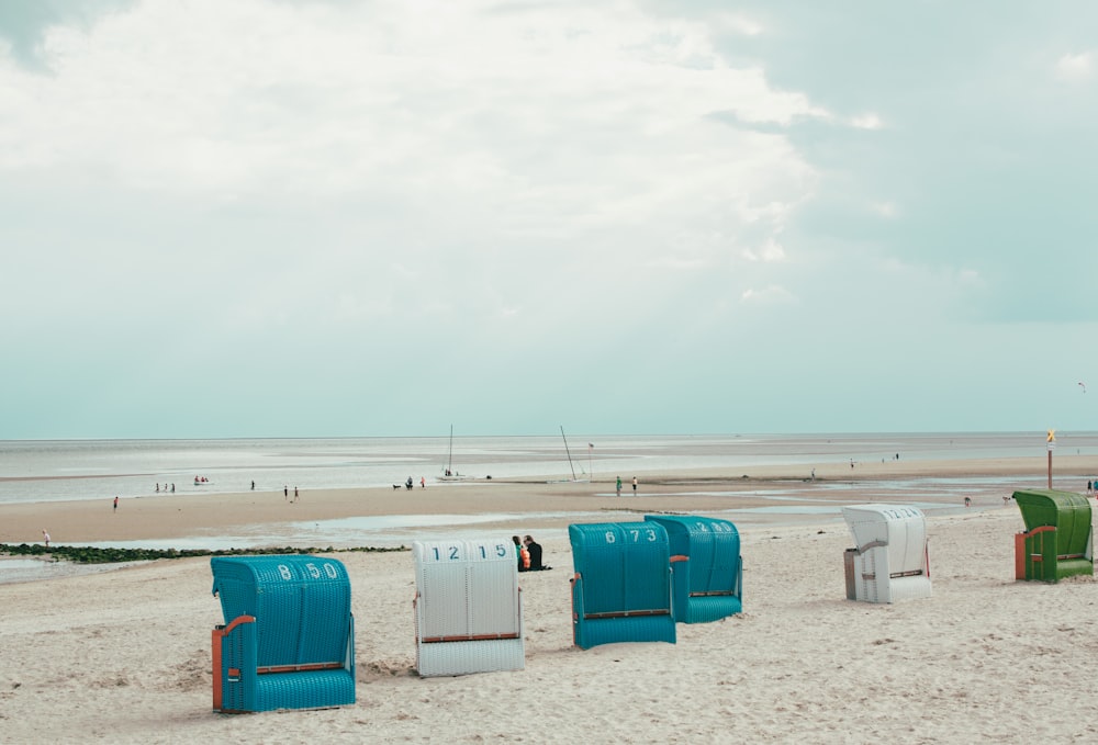 boxes on sand near shore under cloudy sky at daytime