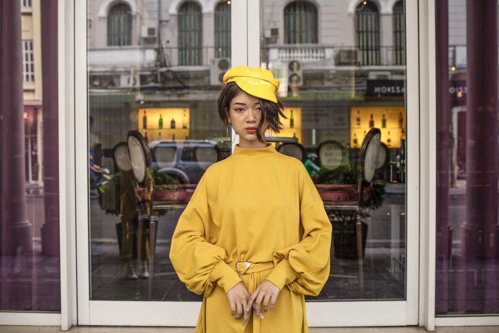 Une femme debout devant une vitrine de magasin