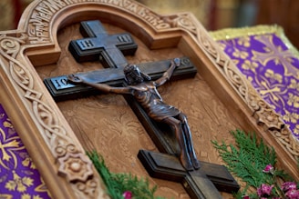 Elegant crucifix with intricate airbrush detailing on a wooden background.