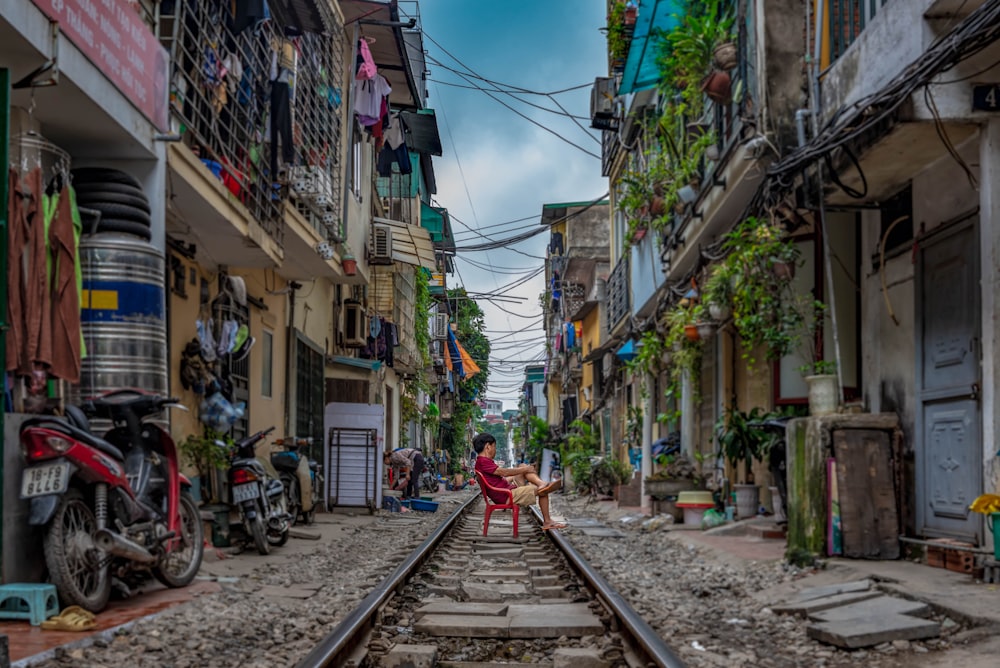 homem sentado na ferrovia