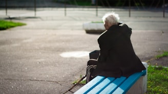 person sitting on wooden bench