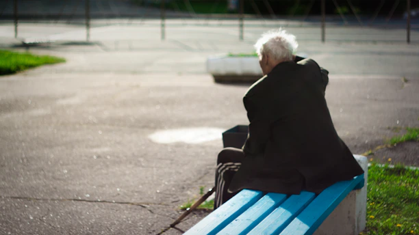 person sitting on wooden bench