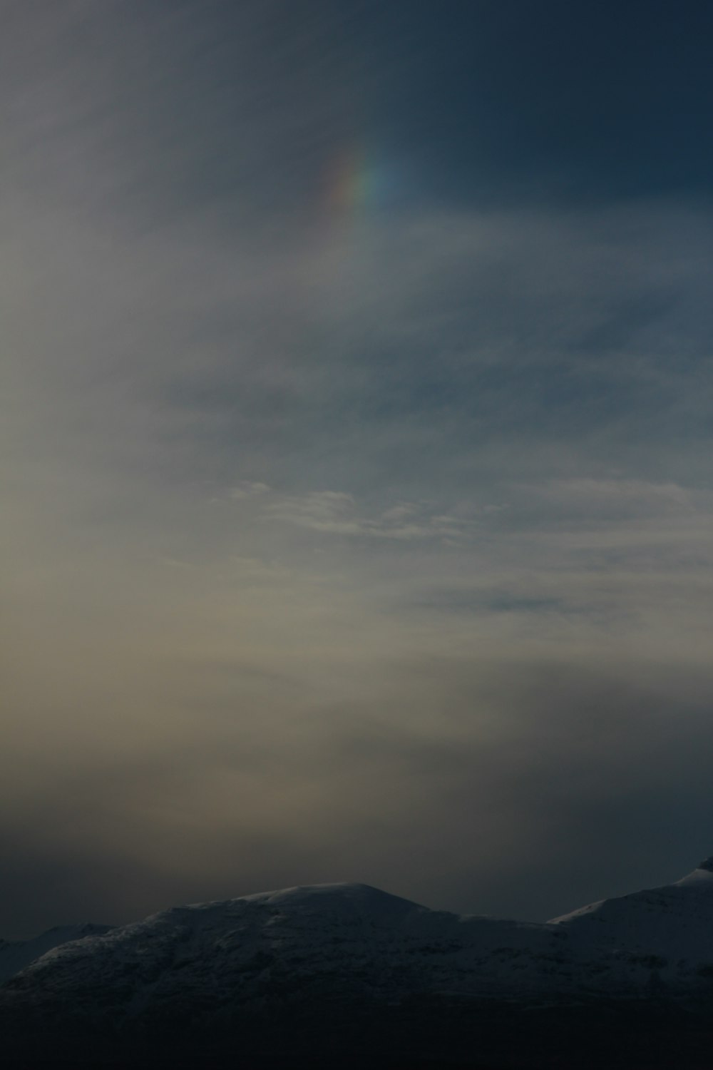 a plane flying in the sky with a rainbow in the background