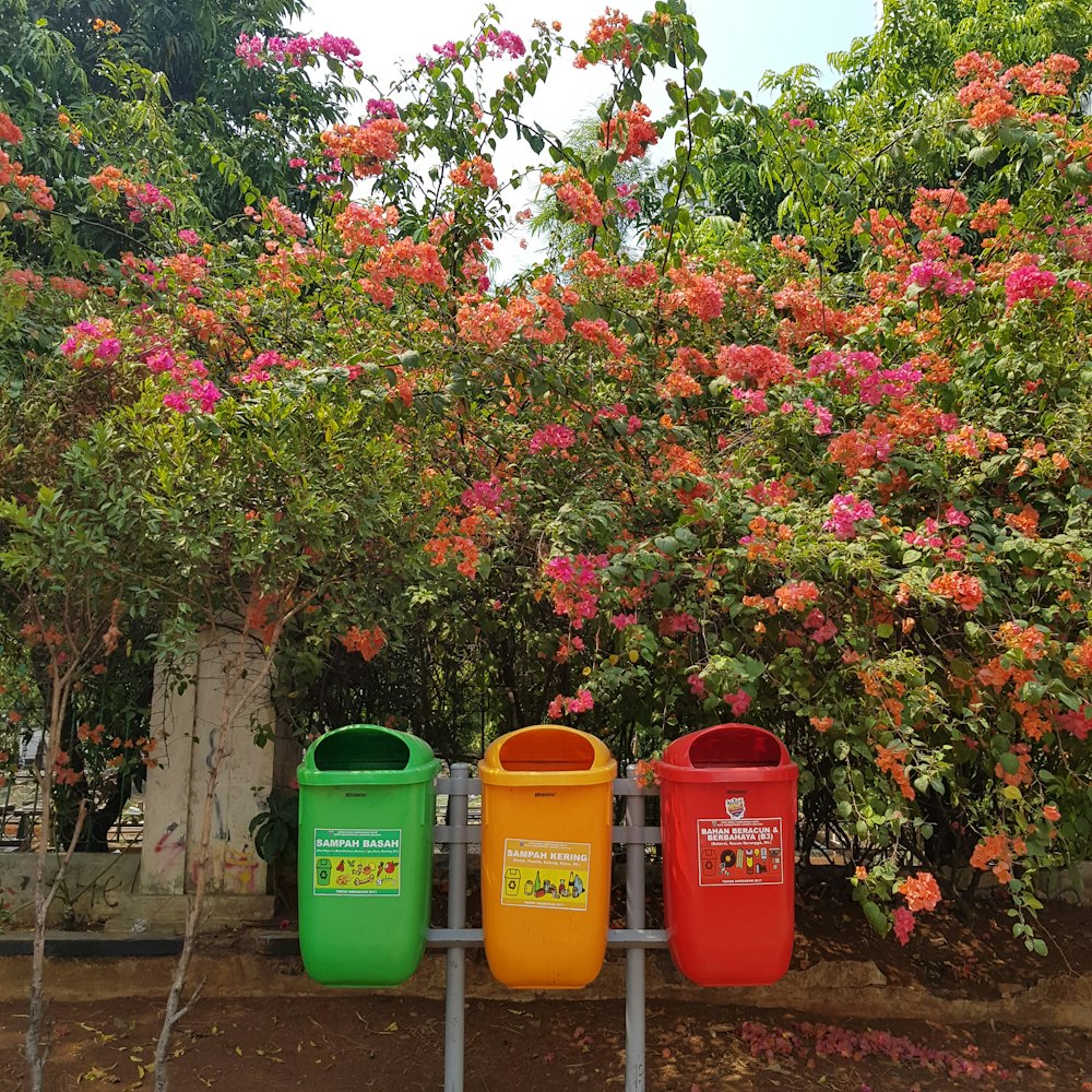 Tres cubos de basura de colores variados