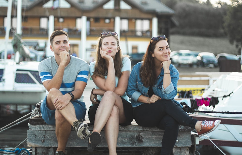 two women and man sitting down on bench