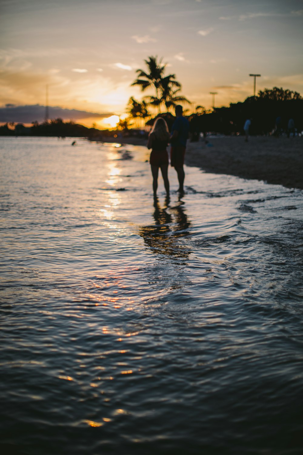 silhouette of couple on seashore during golden hour