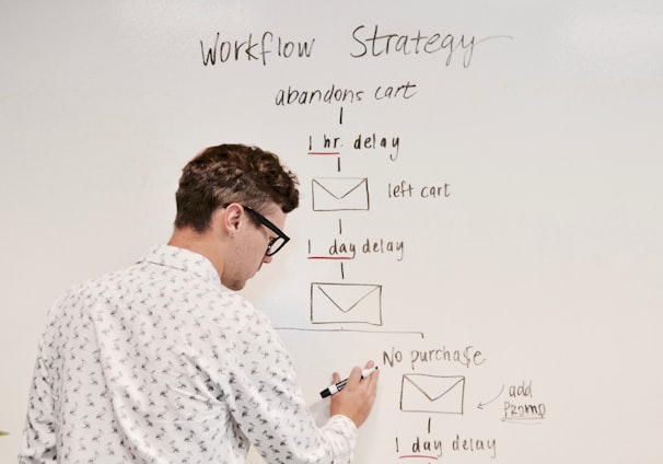 man writing on white board