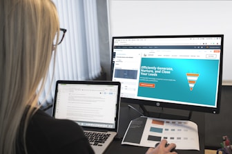 woman sitting in front of turned-on computer monitor