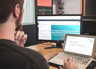 man sitting on chair using silver laptop