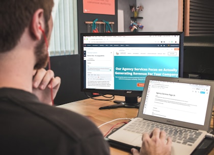 man sitting on chair using silver laptop