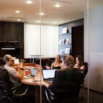 people sitting near table with laptop computer