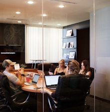 people sitting near table with laptop computer