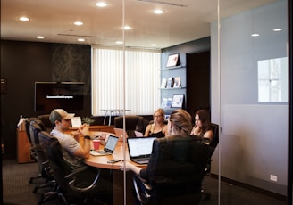 people sitting near table with laptop computer