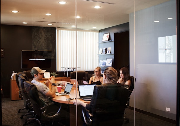 people sitting near table with laptop computer