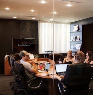 people sitting near table with laptop computer