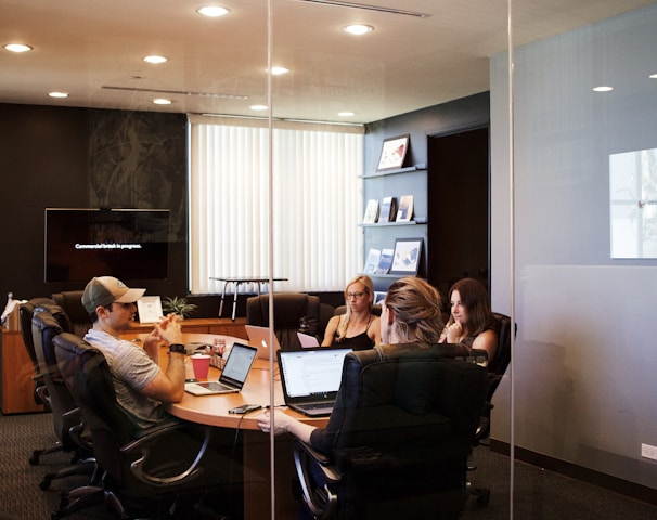 people sitting near table with laptop computer