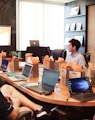 man standing in front of people sitting beside table with laptop computers