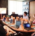 man standing in front of people sitting beside table with laptop computers