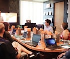 man standing in front of people sitting beside table with laptop computers