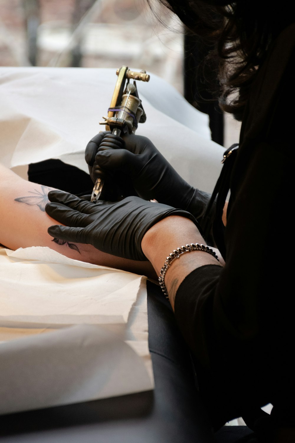 mulher segurando a máquina de tatuagem marrom