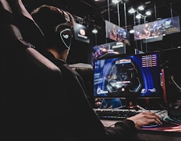 person sitting on gaming chair while playing video game