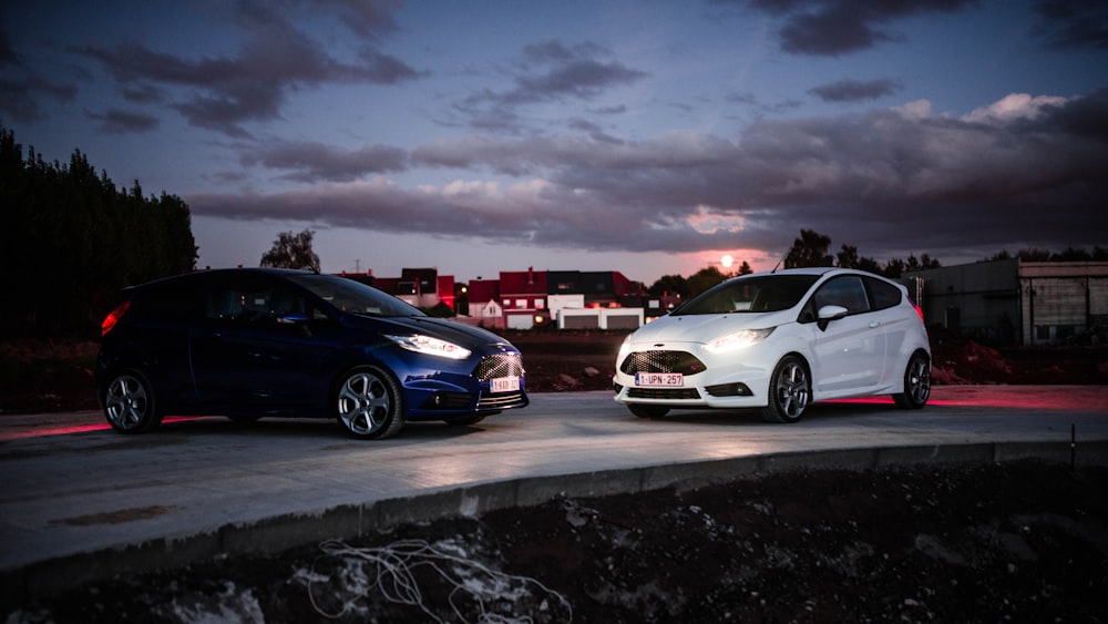 two blue and white Ford Fiesta RS 5-door hatchback on road