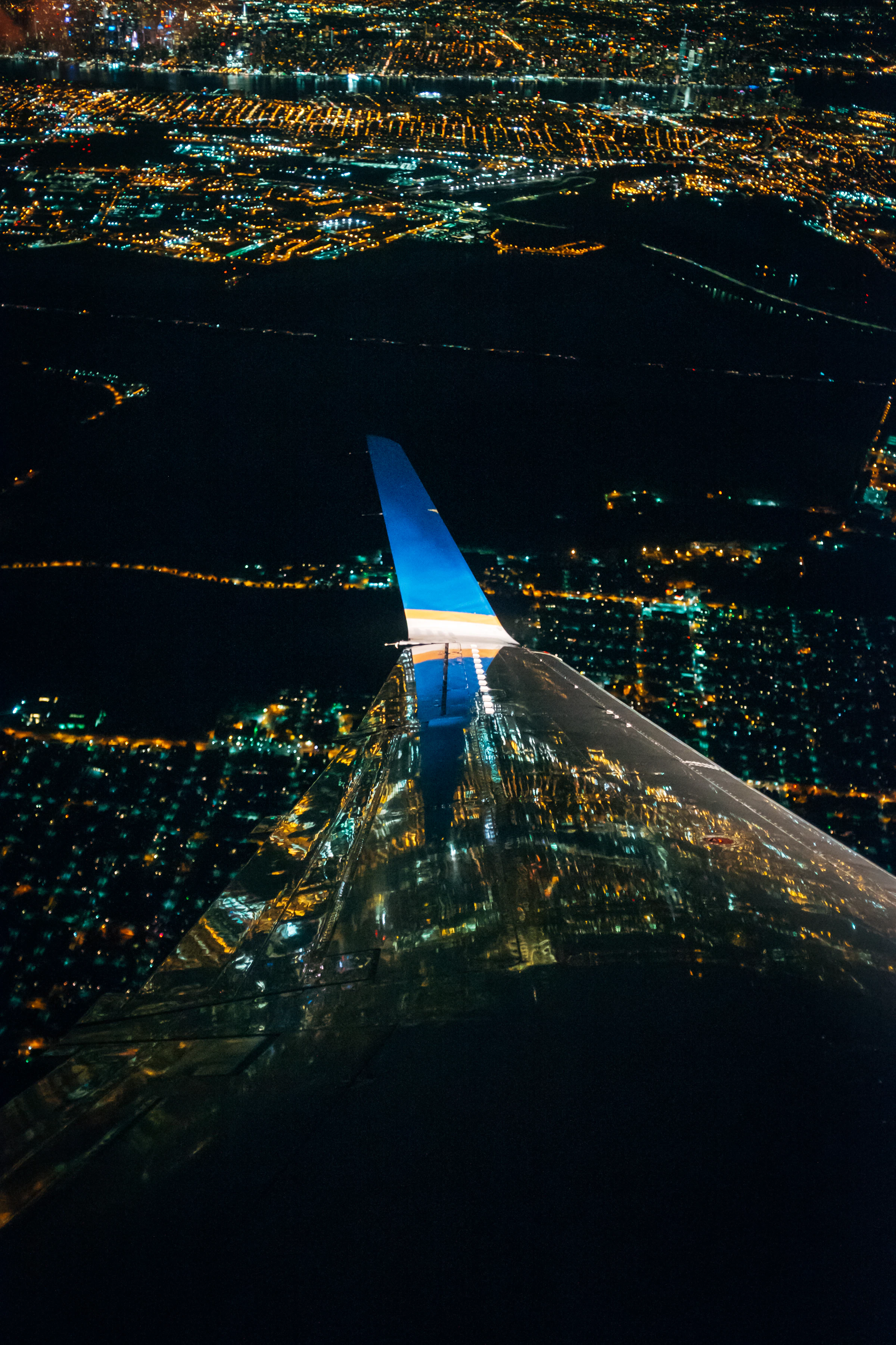 Aircraft wing over a city at night