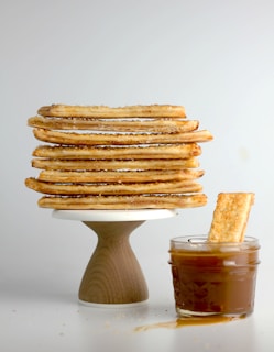 An inviting stack of golden vanilla cakes with delicate cream frosting and cocoa dusting