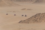 Group enjoying a quad biking session across rocky desert terrain.