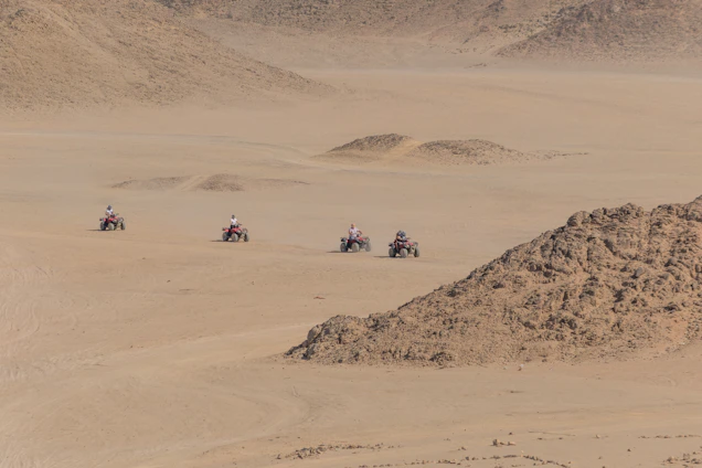 A group of friends enjoying an ATV ride through rugged Texas trails under a bright blue sky.