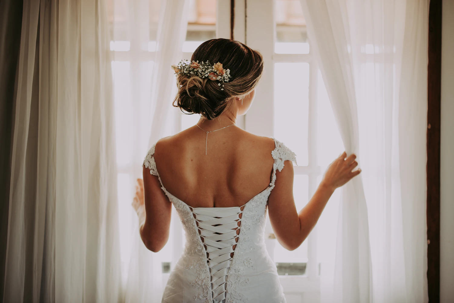 Bride standing by a window before the wedding