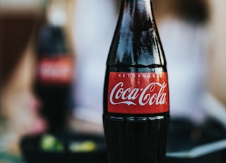 opened Coca-Cola glass bottle with straw