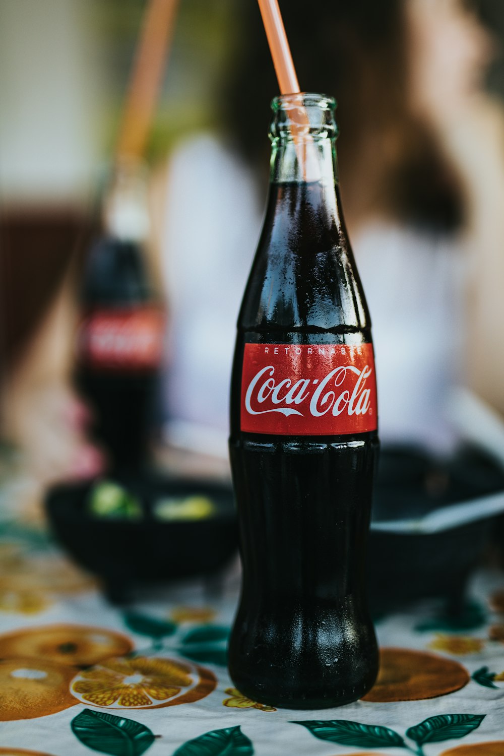 opened Coca-Cola glass bottle with straw