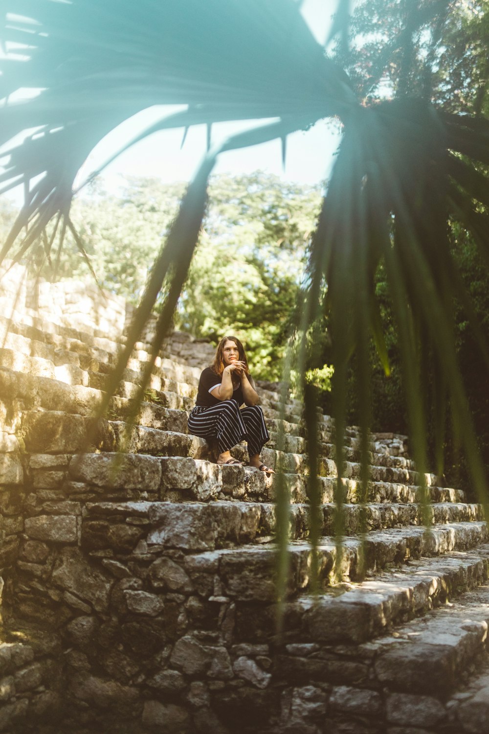 shallow focus photo of woman sitting on concrete stairs