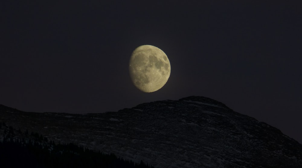 mountain under quarter moon during nighttime