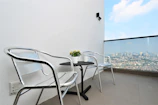 A modern balcony table with decorative items and drinks.