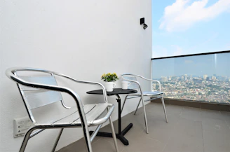 Industrial steel dining set on a modern urban balcony.