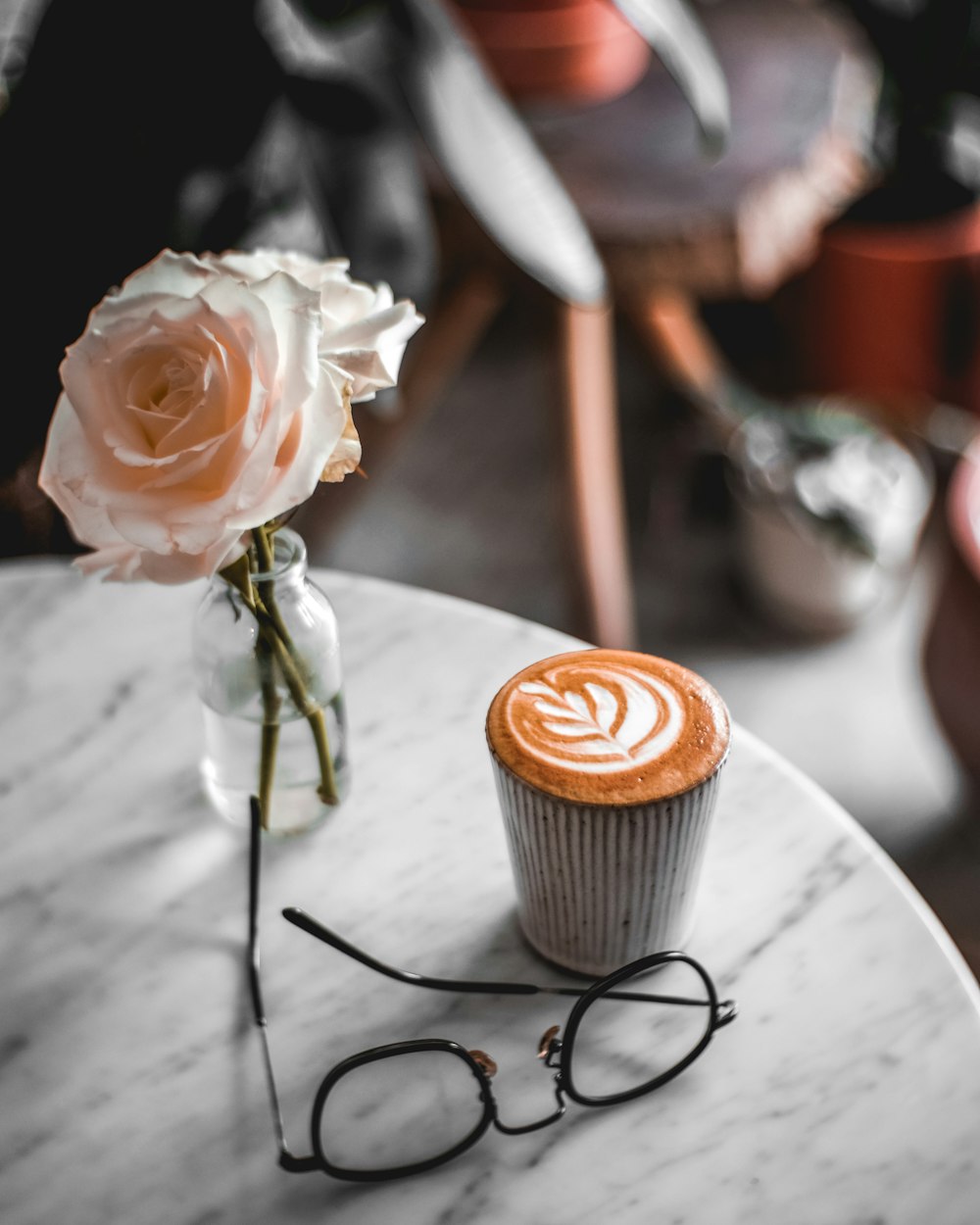 eyeglasses beside glass vase