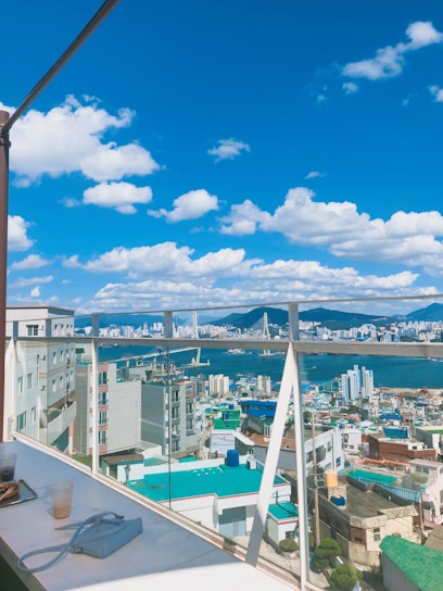 A vibrant cityscape background with a stylish tote bag resting on a café table, sunlight casting warm shadows.