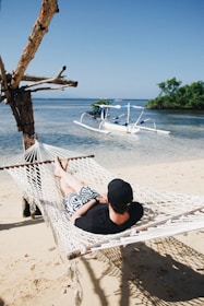 person lying on hammock during daytime