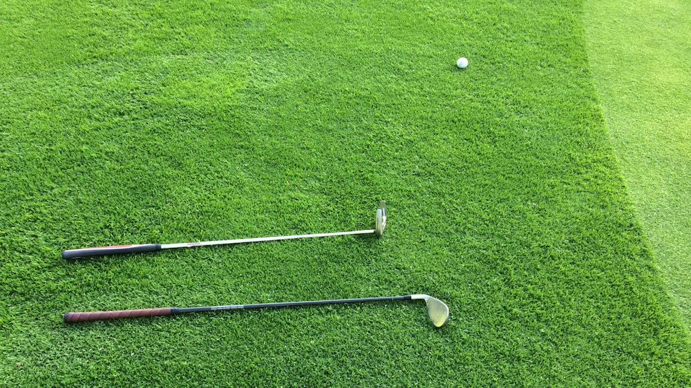 deux clubs de golf sur un terrain en herbe verte
