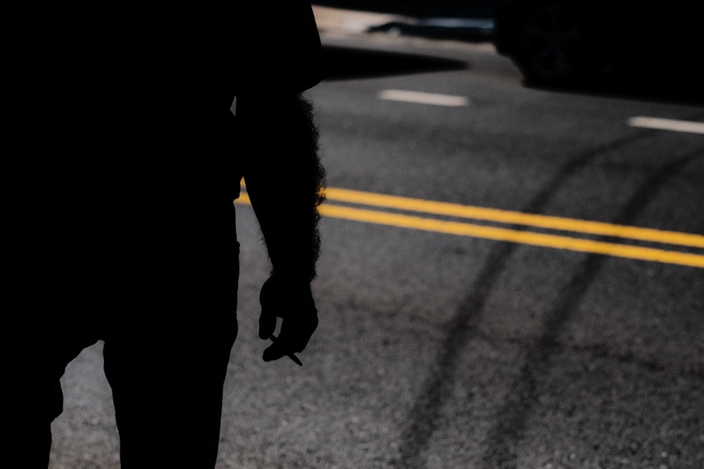 silhouette of man holding cigarette stick