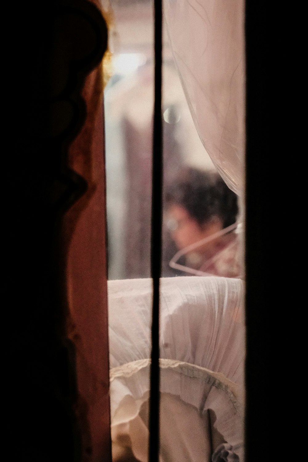 a woman sitting on a bed looking out of a window