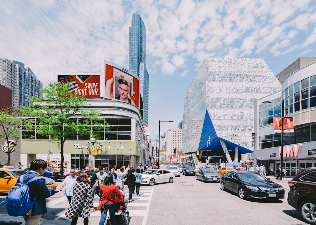 cars on road while people walking on pedestrian lane during daytime