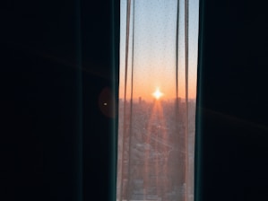An inspiring sunrise viewed through a window, symbolizing fresh starts.